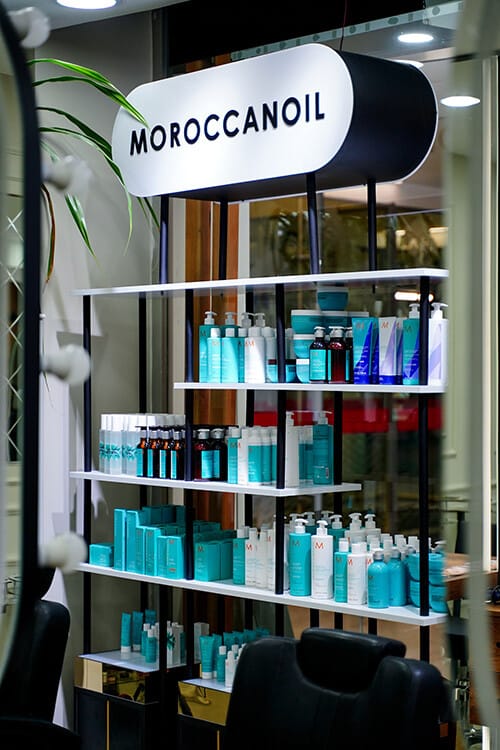 Moroccanoil hair care product shelf with branded display lighting