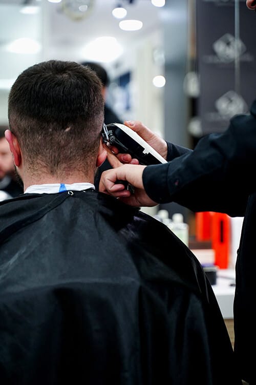 Men's haircut: nape and sides being shaped with clippers in the barber chair