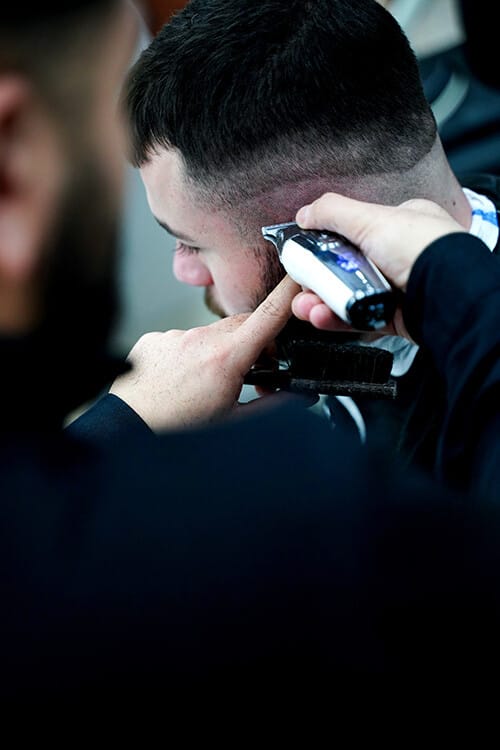 Fade haircut in progress, the temple blend being cut with clippers