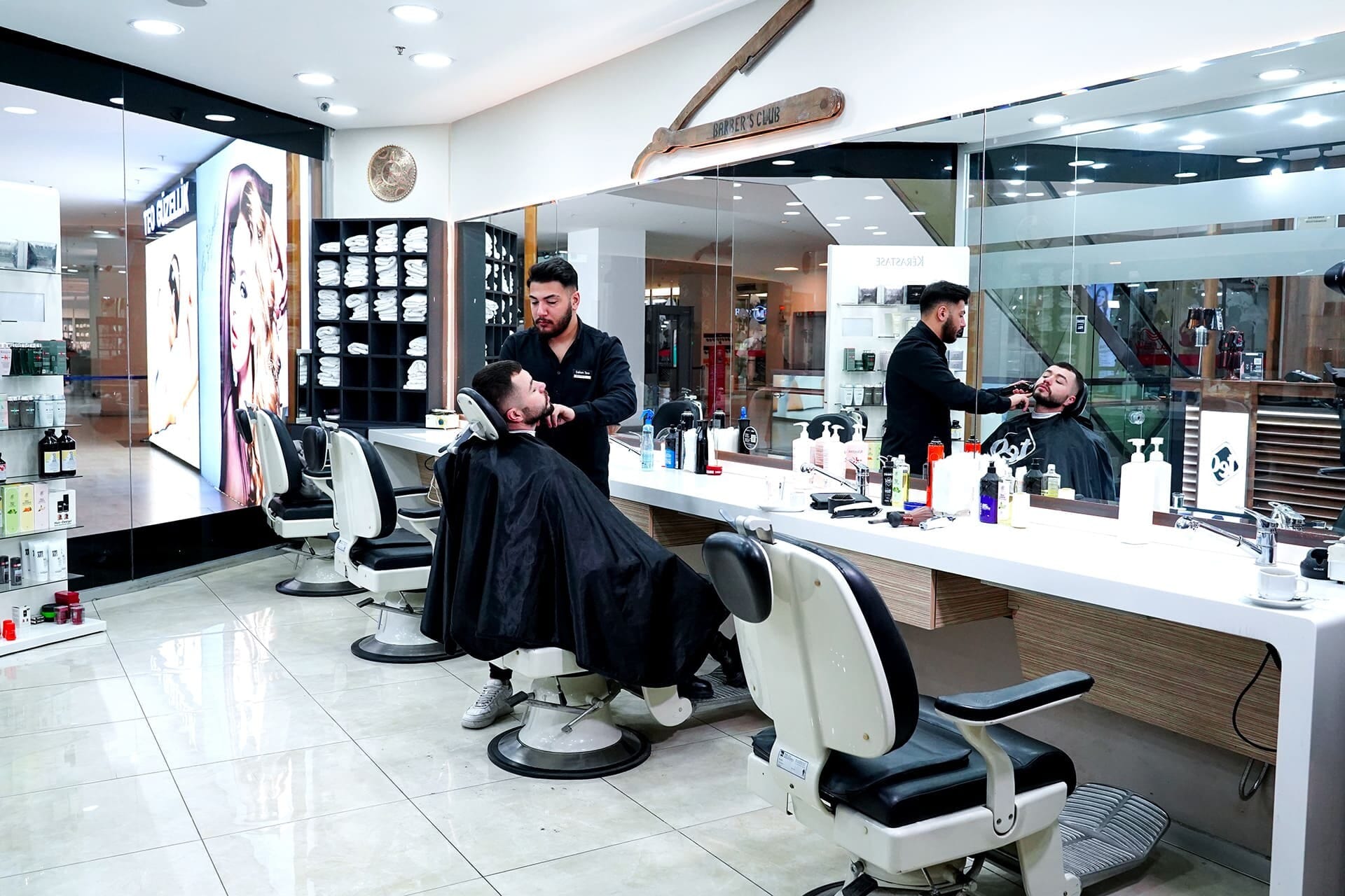 The men's barber section: barber chairs, mirror row and the team at work