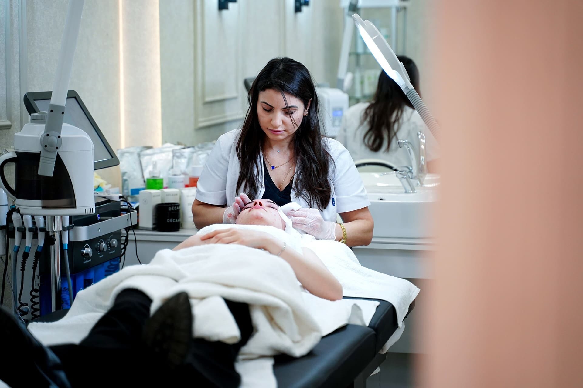 An aesthetician performing a facial treatment in the skincare room