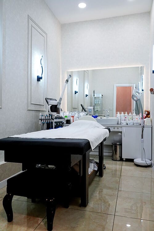 The skincare room: treatment bed, steamer and magnifying lamp